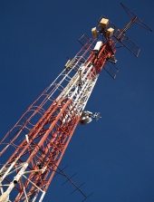 Červeno bílý rádiový vysílač na pozadí s modrou oblohou