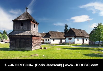 Dřevěná zvonice a lidové domy ve skanzenu Pribylina na Slovensku